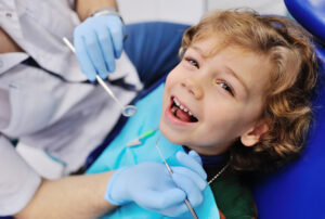 little boy sitting in dentist chair smiling